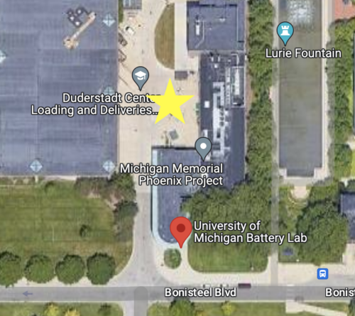 Satellite map of the University of Michigan Battery Lab with a yellow star indicating the loading area behind the building